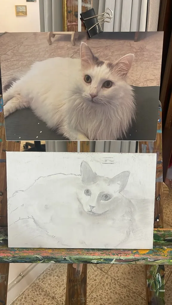 The client’s photo of a long-haired white cat, clipped to the easel.